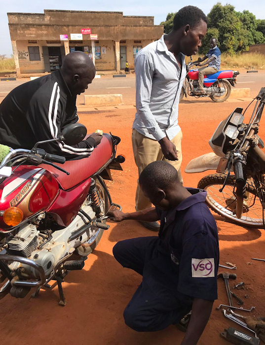 Jokene from Tam Anyim working on a Bajaj Boxer and Yahama 125 at the same time